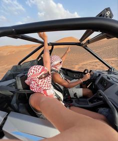 two people in a vehicle driving through the desert