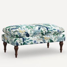 an upholstered footstool with blue and green floral print on the back