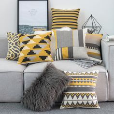 a couch with many pillows on it and a framed photograph above the couch in front of it