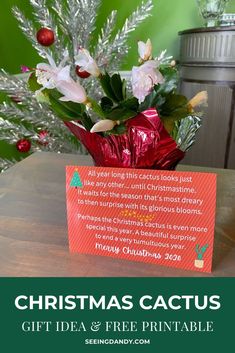 a christmas card sitting on top of a table next to a vase filled with flowers