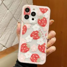 a woman is holding up her phone case with strawberrys on the front and flowers on the back