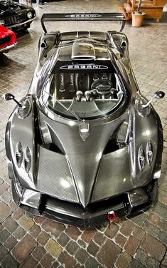 a silver sports car parked on top of a brick floor