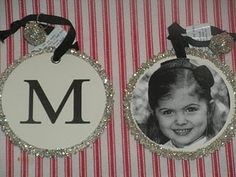 two personalized christmas ornament hanging on a striped tablecloth with red and white stripes