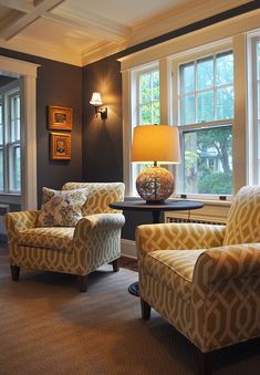 a living room with two chairs and a lamp