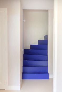 a blue stair case in an empty room