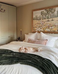 a dog laying on top of a white bed in a bedroom next to a chandelier