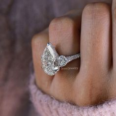 a woman's hand with a diamond ring on it