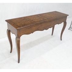 an old wooden table sitting on top of a white floor