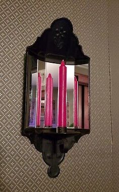 a wall mounted candle holder with pink candles