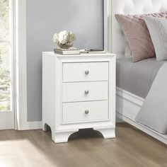 a white night stand with two drawers and a mirror on top of it in a bedroom