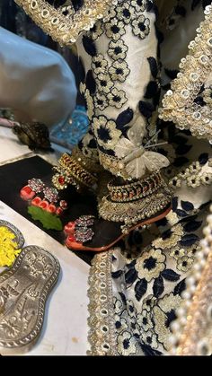 several pairs of shoes are on display in front of other items that include brooches and beads