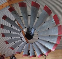 a large metal windmill sitting on top of a wooden floor