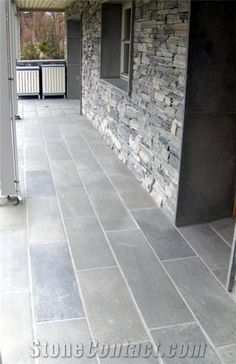 an outdoor patio with stone walls and flooring