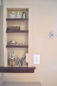 the bathroom shelves are filled with toiletries and personal care items in their respective niches