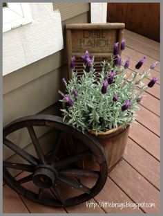 an old wagon with flowers in it is sitting on the porch next to a planter