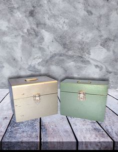 two suitcases sitting side by side on a wooden floor in front of a concrete wall