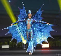 a woman in a blue costume on the runway