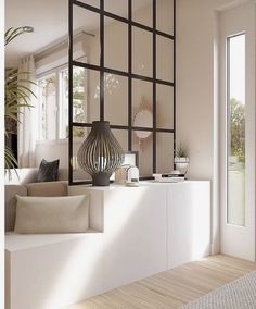 a living room filled with white furniture and lots of window panes on the wall