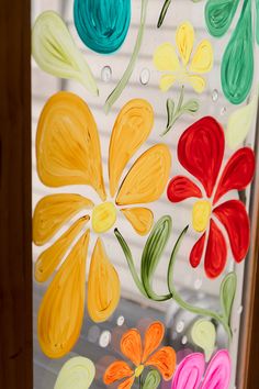 a glass window with flowers painted on it