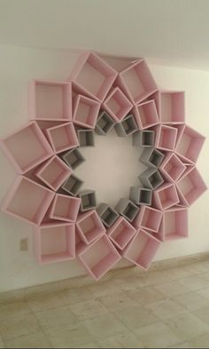 a circular mirror made out of pink bookshelves in the shape of a flower