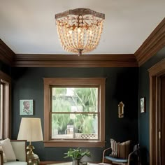 a living room filled with furniture and a chandelier hanging from the ceiling next to a window