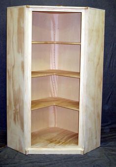 a wooden shelf with three shelves and no one in it on a black background,