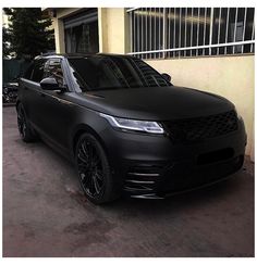 a black range rover parked in front of a building