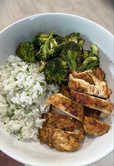 a white bowl filled with rice, meat and broccoli