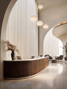 an elegant reception area with curved walls and wooden accents, along with modern chairs and tables