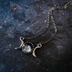 "Personalized and petite, this necklace is the perfect sentimental gift for your favorite stargazer. This pendant has the phase of the moon that was shining in the sky from the date of your choosing (past, present, or future) and is flanked by two crescent moons. Small enough for everyday wear, yet special enough to be treasured. To order, please provide the following information : Date (in this format: MM/DD/YYYY), Time Zone, and Approximate Time Of Day (if possible) of the date you wish to cel Half Moon Metal Necklace For Gift, Half Moon Metal Necklace For Gifts, Adjustable Moon Phase Necklace, Celestial Metal Necklace With Moon Charm, Celestial Moon-shaped Metal Necklaces, Adjustable Moon Phase Celestial Necklace, Adjustable Moon Phase Celestial Necklaces, Celestial Moon-shaped Metal Necklace, Symbolic Moon-shaped Metal Necklace