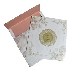 two wedding cards in a pink and white box