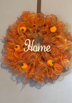 an orange mesh wreath with the word home written on it