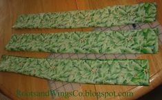 four pieces of green fabric sitting on top of a wooden table