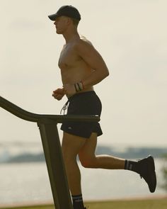 a shirtless man running down a metal hand rail