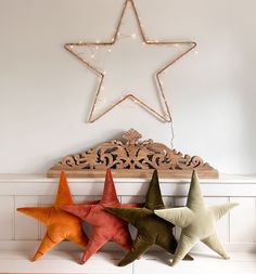 three star shaped pillows sitting on top of a mantle