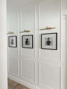 three black and white photos hang on the wall in an empty room with tile flooring