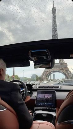 a man sitting in the driver's seat of a car looking at an electronic device