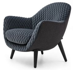 an upholstered chair with black legs and a blue quilted fabric on the back