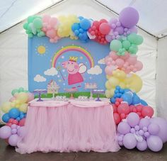 there is a pink table with balloons on it and a peppa pig sign in the middle