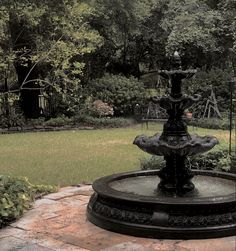 a water fountain sitting in the middle of a garden