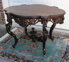 an ornately carved wooden table on a rug in front of a white garage door