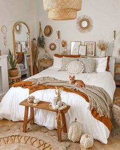 a cat is laying on the bed in a bedroom with white walls and wood floors