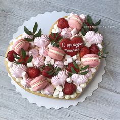 a heart shaped cake decorated with strawberries and meringue