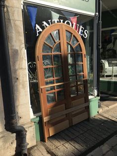 an old wooden door on the side of a building in front of a storefront