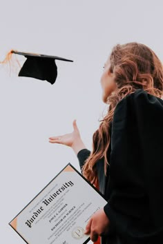 a woman in graduation gown holding a diploma