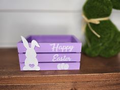 a purple box with an easter bunny cut out on it and a green plant in the background