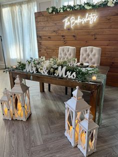 a long table with candles and flowers on it in front of a sign that says mr and mrs