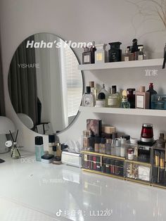 a white counter top sitting under a mirror next to a shelf filled with bottles and cosmetics