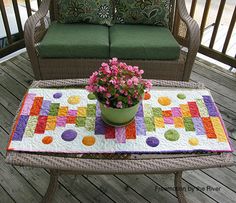 a potted plant sitting on top of a table next to a green couch and chair