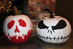 two painted pumpkins sitting next to each other